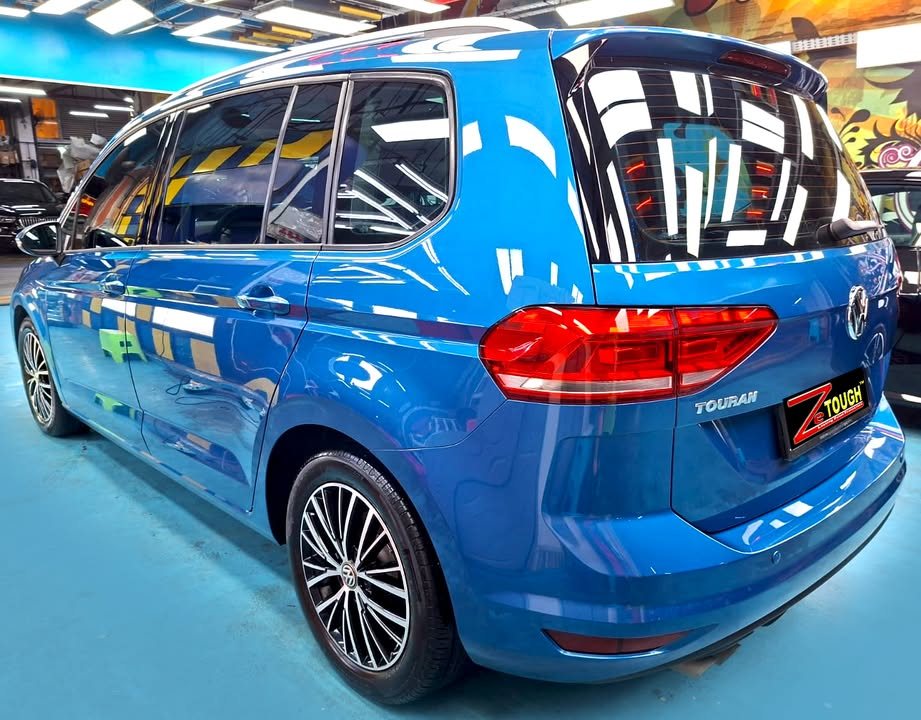Rear three-quarter view of the blue Volkswagen Touran.