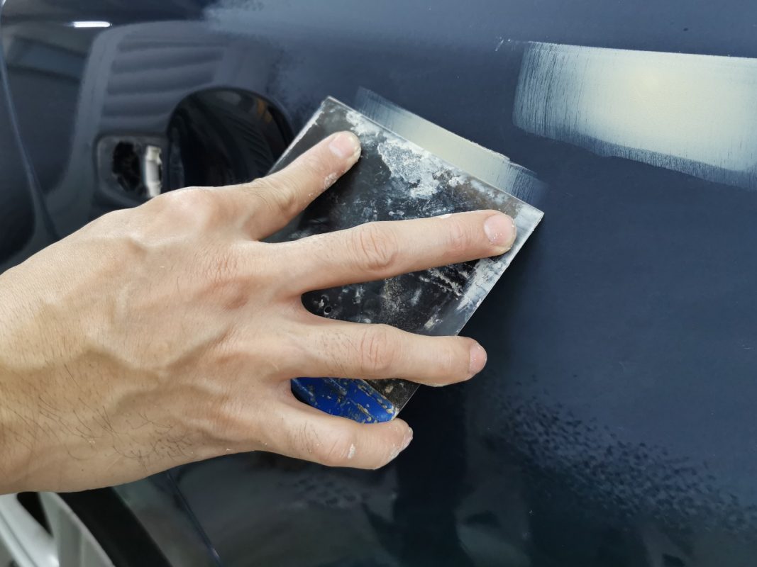 The S60's paintwork being examined for scratches and chips.