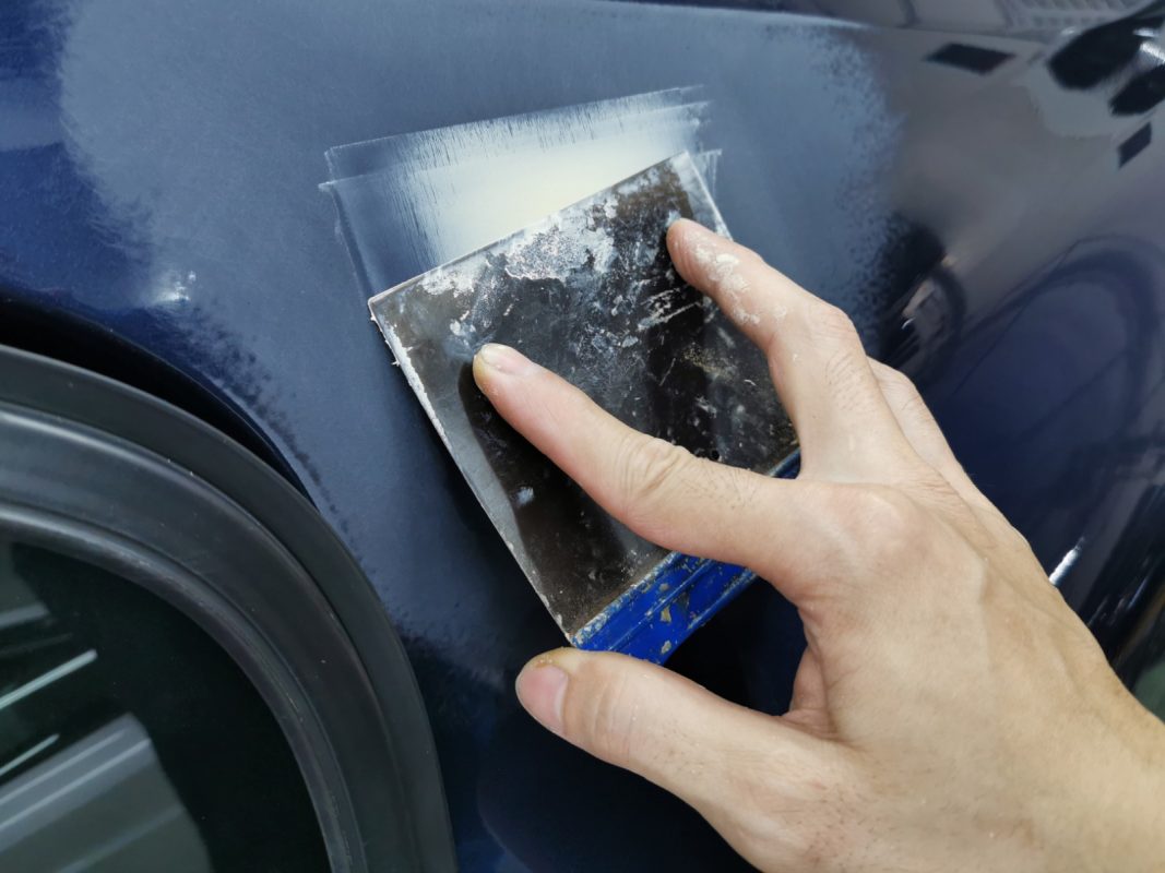 Putty being applied to level the uneven areas on the S60's body.
