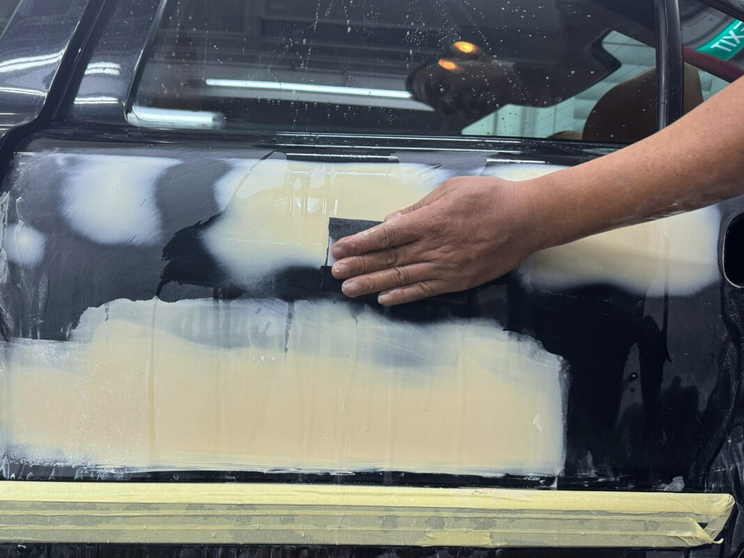 Wet-sanding the Volvo S60R's surface to level the primer and smooth every panel.