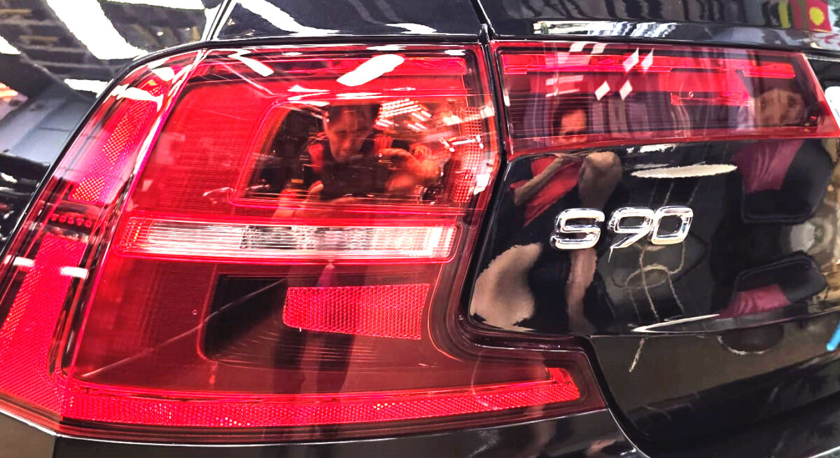 Coated bonnet of the Volvo S90 under workshop lighting.