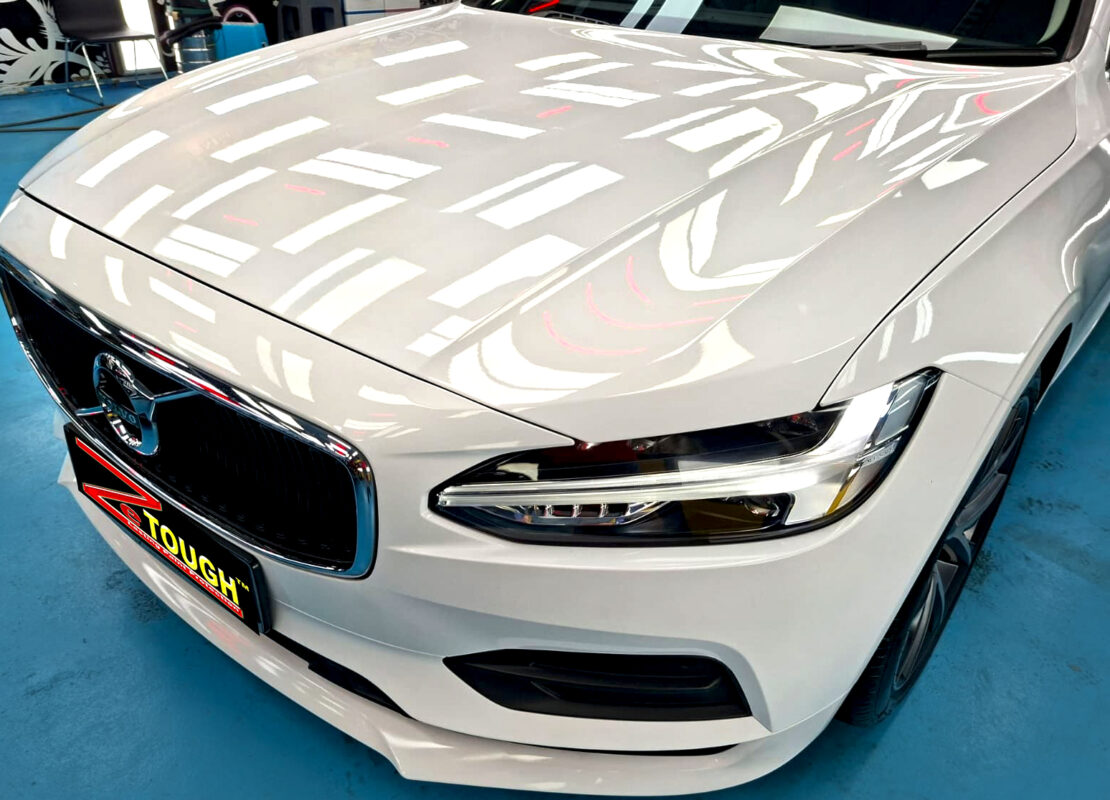 The Volvo S90's coated paintwork under workshop lighting.