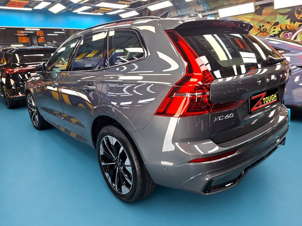 Rear three-quarter view of the grey Volvo XC60 with its tall red tail lights.