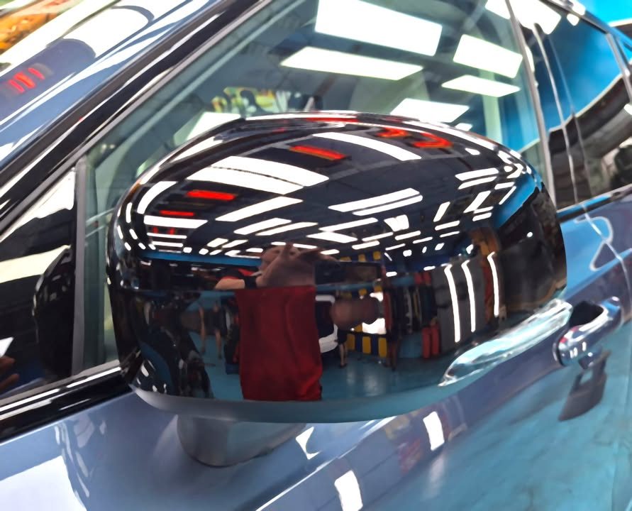 Gloss black mirror cap on the XC90 reflecting the workshop.