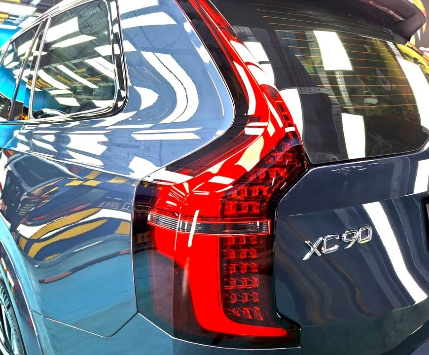 Close-up of the XC90 tail light and badge on the blue tailgate.
