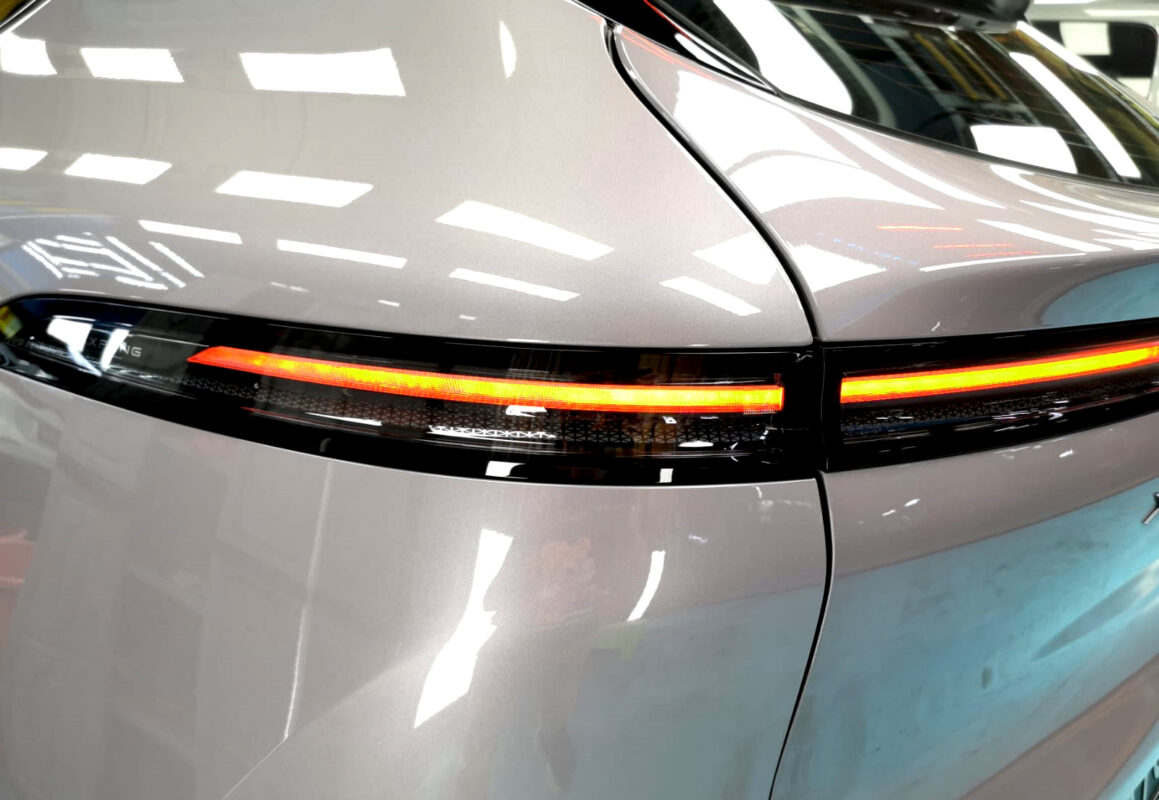 The coated bonnet of the XPeng G6 under workshop lighting.