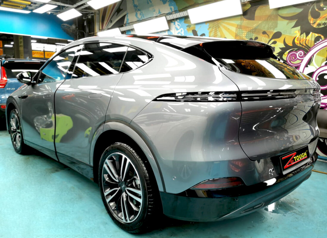 Coated bonnet of the XPeng G6 under workshop lighting.