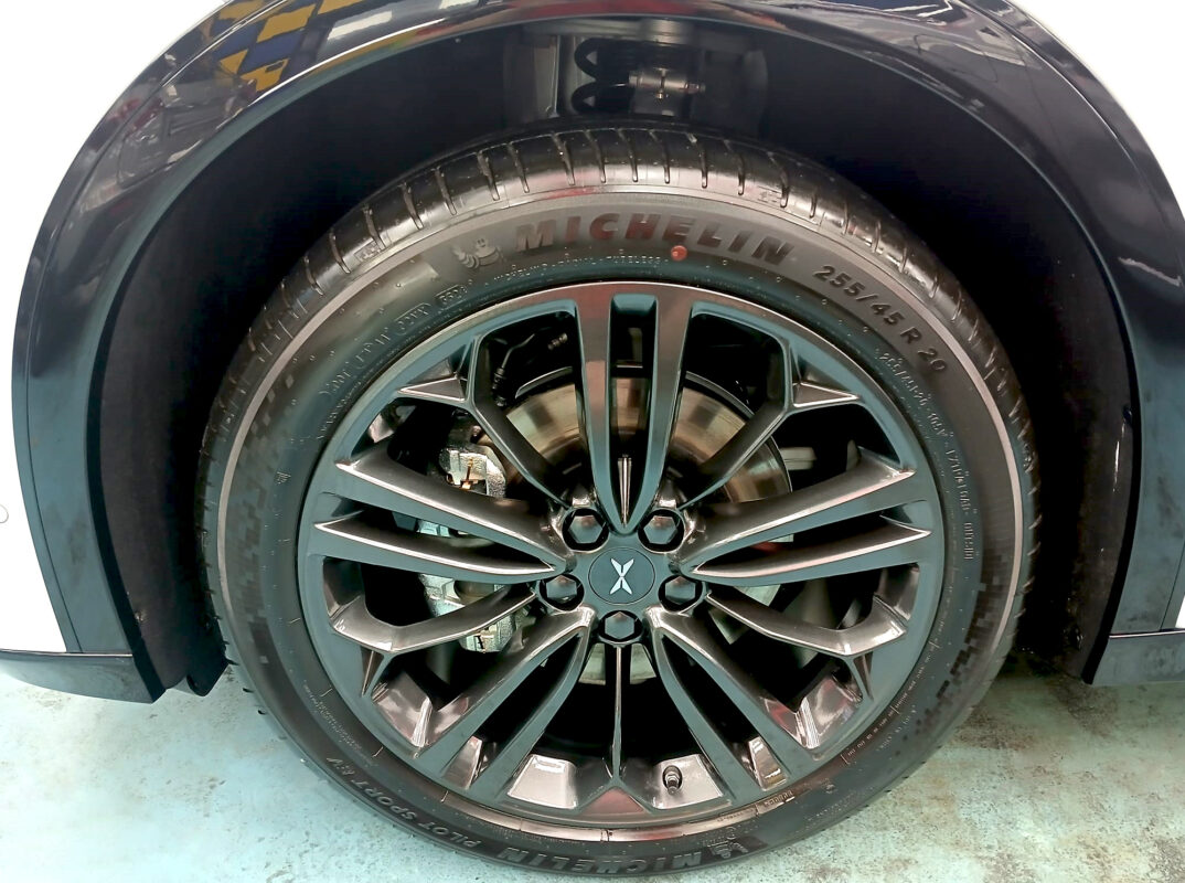Coated bonnet of the XPeng G6 RWD under workshop lighting.