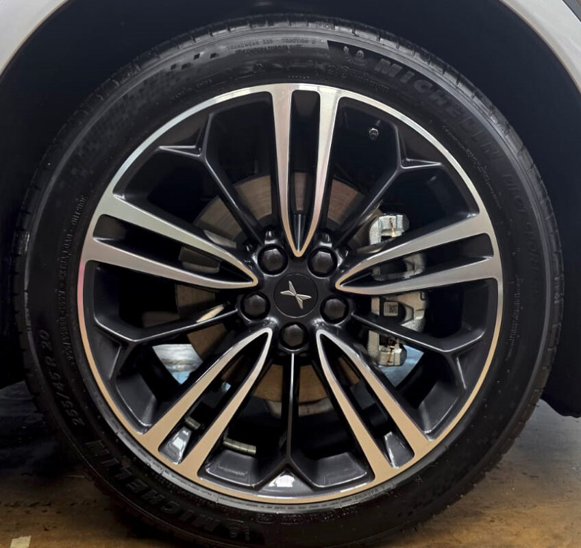 The coated bonnet of the XPeng G6 under workshop lighting.