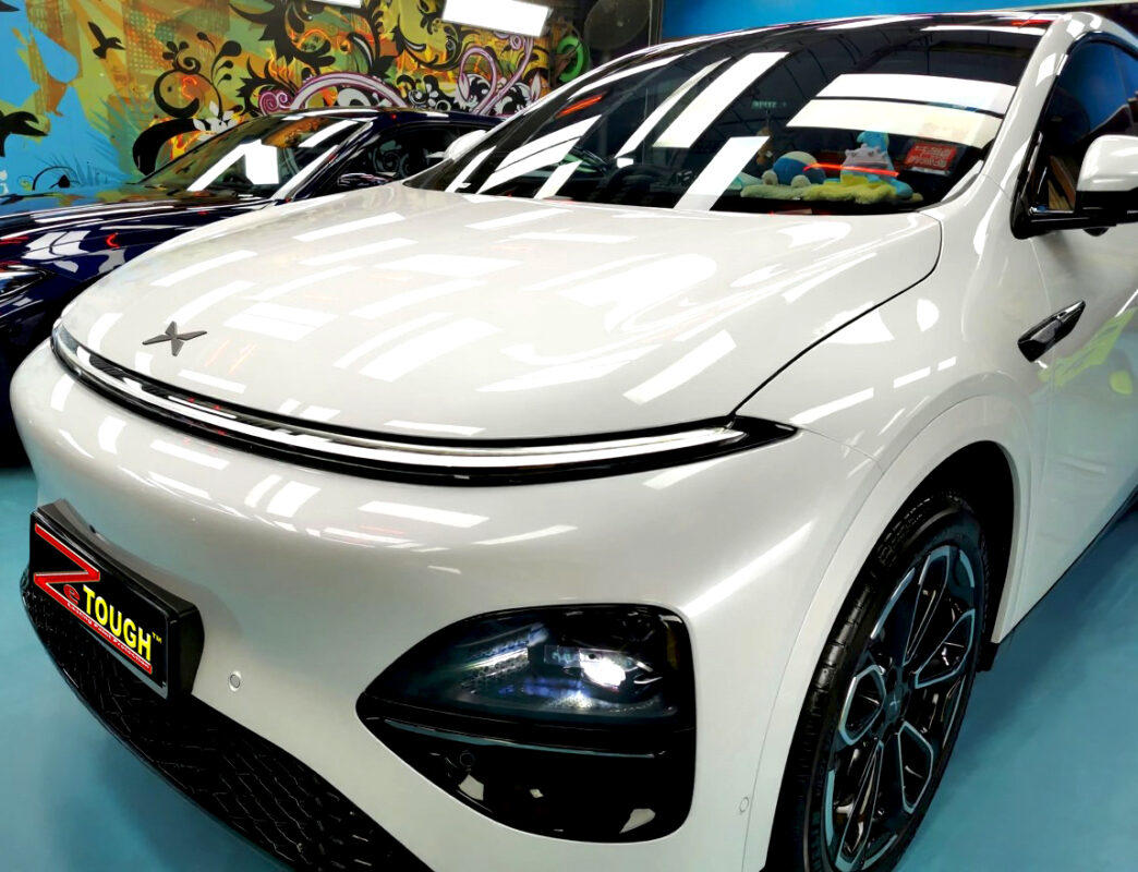 The XPENG G6's coated paintwork under workshop lighting.