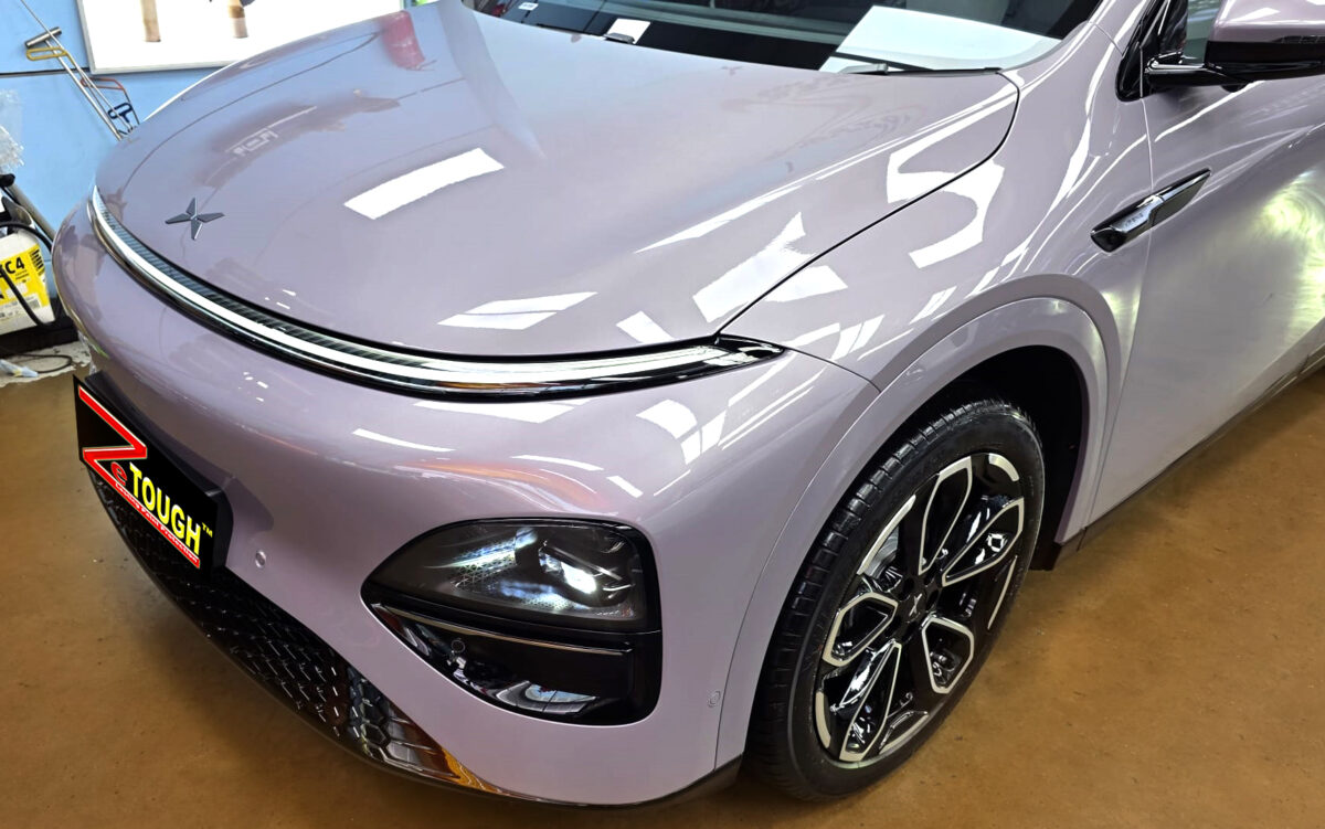 The XPENG G6's coated paintwork under workshop lighting.