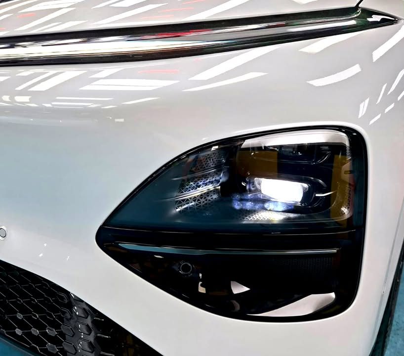 Close-up of the Xpeng G6 headlamp housing in the white front bumper.