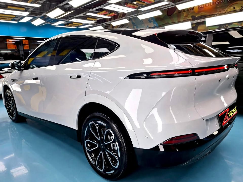 Rear three-quarter view of the white Xpeng G6 in the workshop.