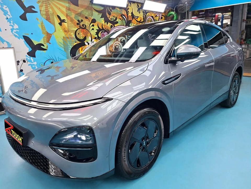 Grey Xpeng G6, front three-quarter view, in the Revol Carz workshop after coating.