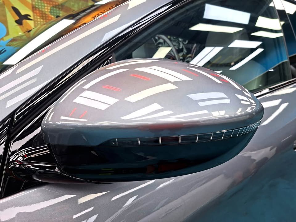 Grey wing mirror on the Xpeng G6 with sharp light reflections.