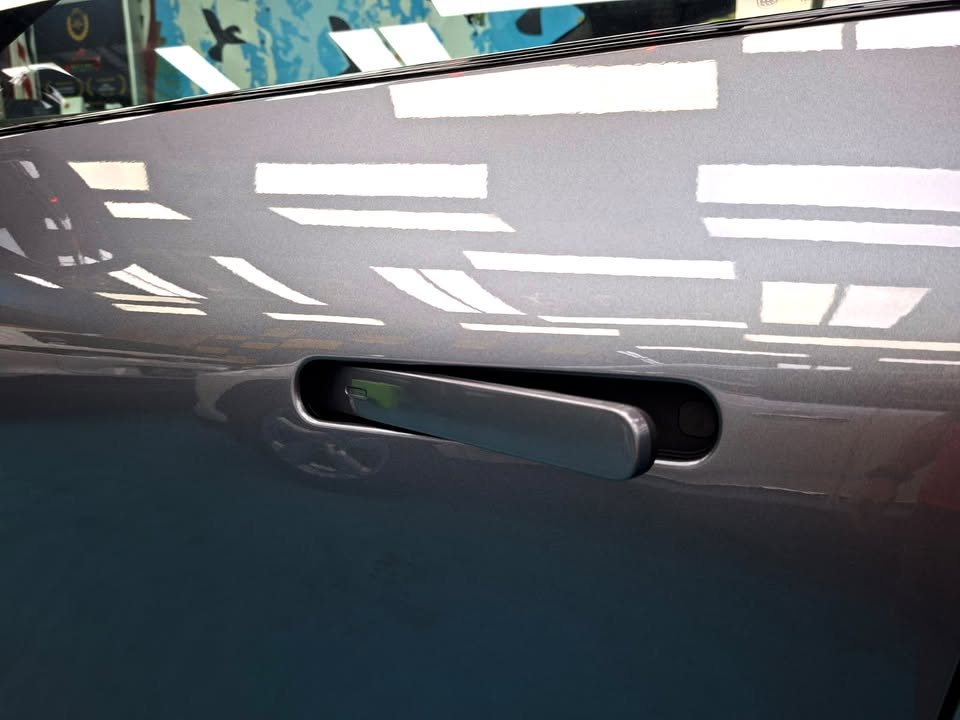 Flush door handle on the grey door panel.