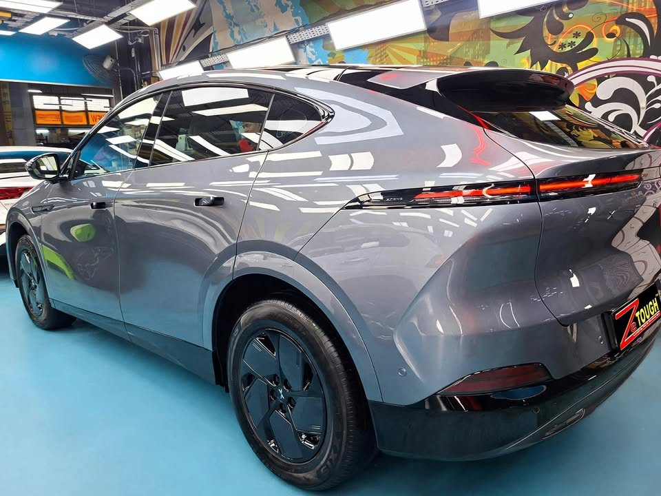 Grey Xpeng G6, rear three-quarter view, in the workshop.
