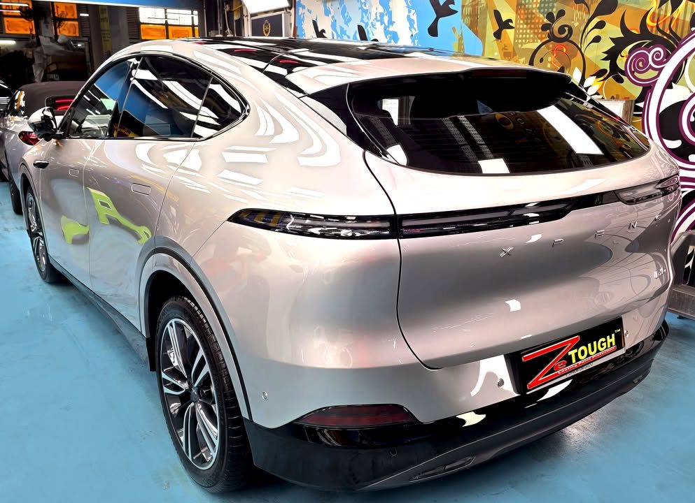 Rear three-quarter view of the silver Xpeng G6 with its full-width tail lamp.
