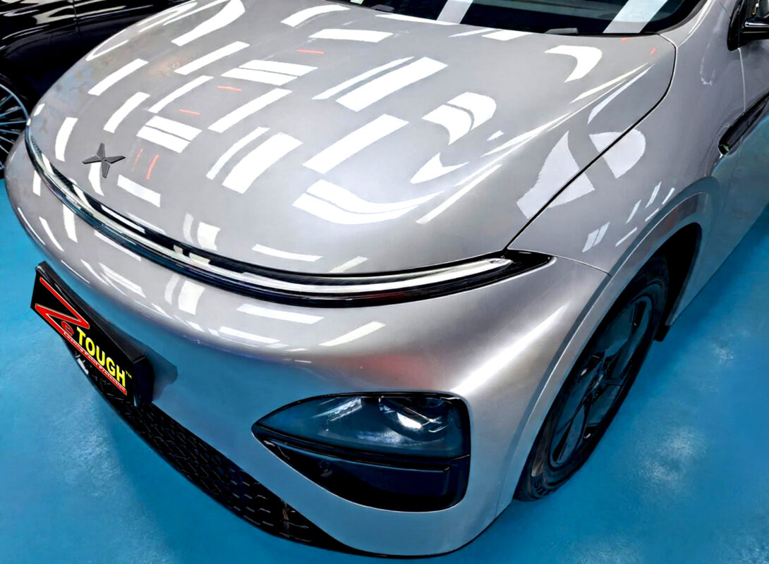 The XPENG G6's coated paintwork under workshop lighting.