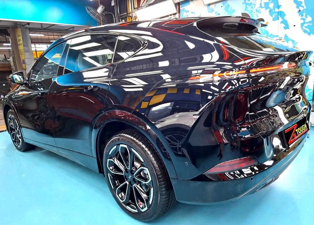 Rear three-quarter view of the black XPeng G6 with two-tone alloy wheels.