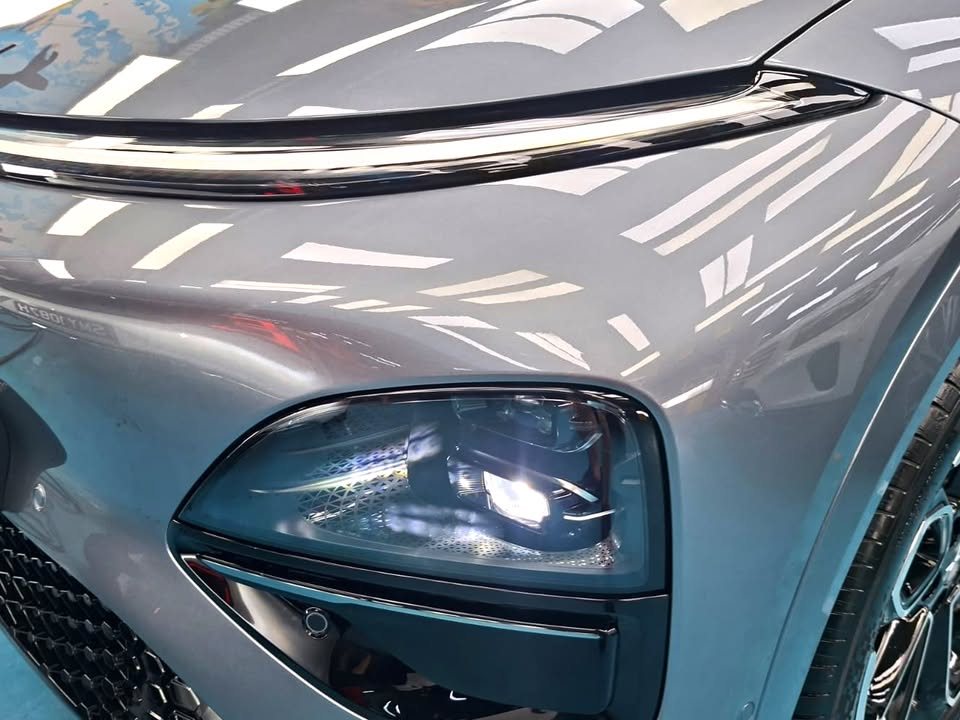 Close view of the Xpeng G6 headlight and grey front wing.