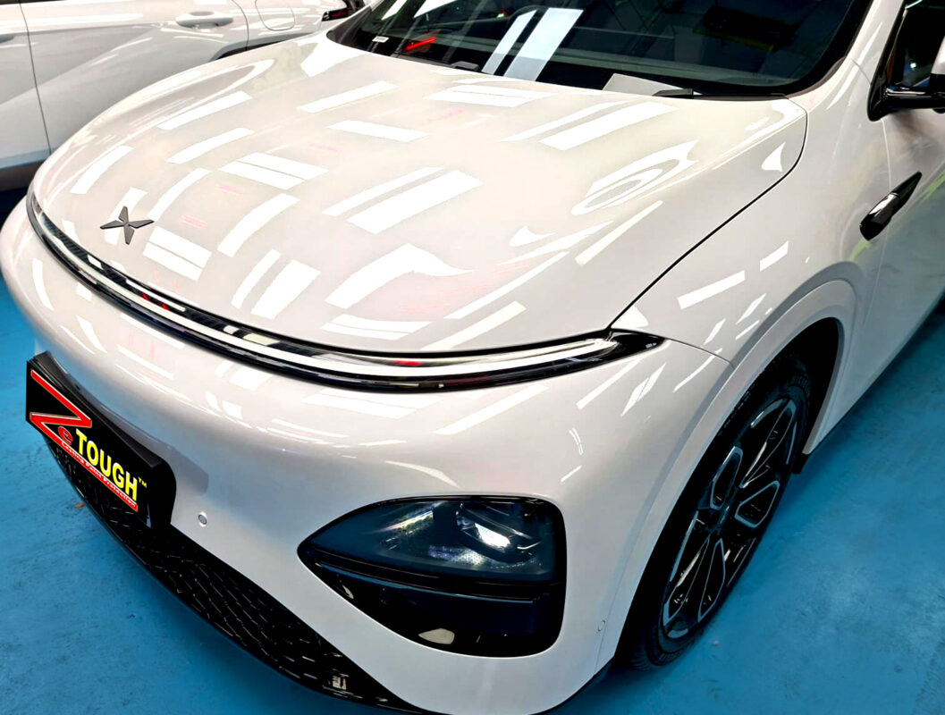 The XPENG G6's coated paintwork under workshop lighting.