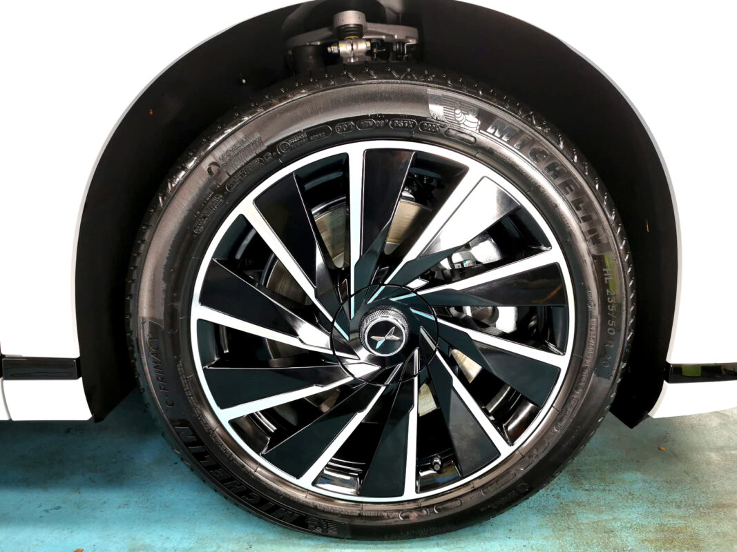 The coated bonnet of the XPeng X9 under workshop lighting.