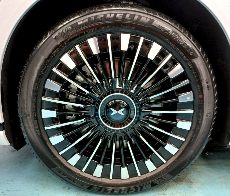 The coated bonnet of the XPeng X9 under workshop lighting.