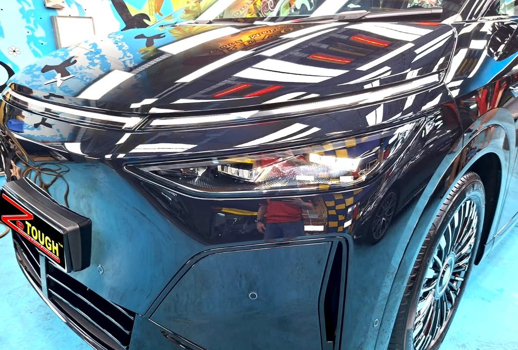 Front of the X9 showing the light bar and bonnet reflecting the ceiling lights.