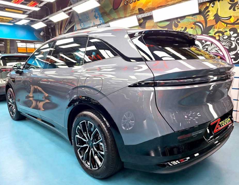 Rear three-quarter view of the grey Zeekr 7X showing the light bar and wheel.