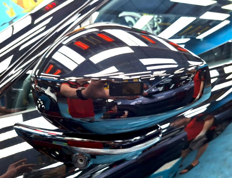 Black door mirror on the Zeekr 7X with sharp reflections of the workshop ceiling.