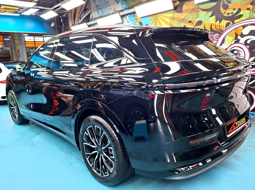 Rear three-quarter view of the black Zeekr 7X in the workshop.