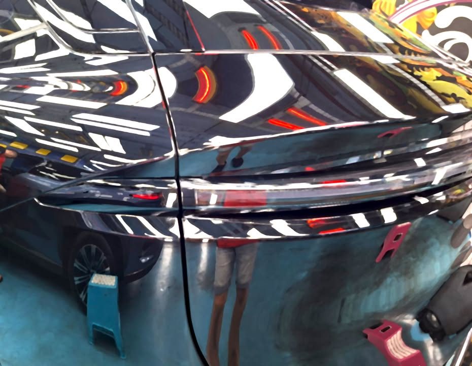 Close-up of the Zeekr 7X's rear light bar and rear quarter in black paint.
