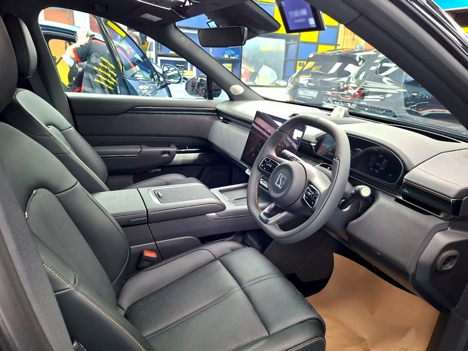 Black leather front seats, steering wheel and dashboard screens inside the Zeekr 7X.