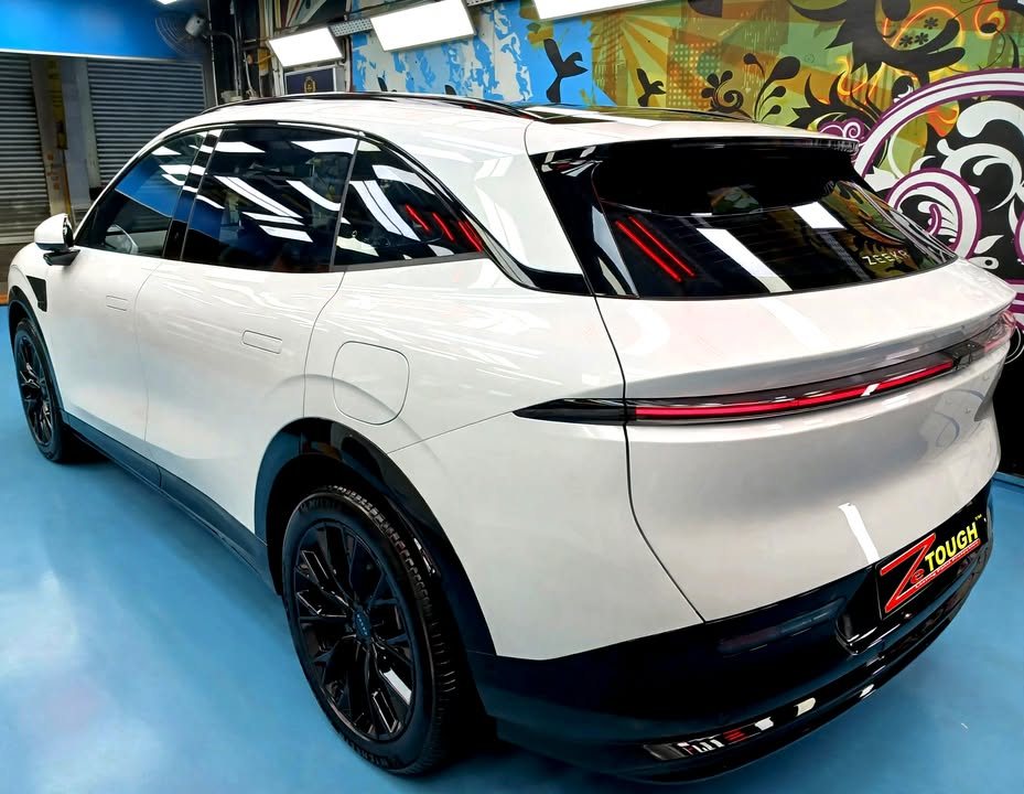 Rear three-quarter view of the white Zeekr 7X with its full-width tail lamp.