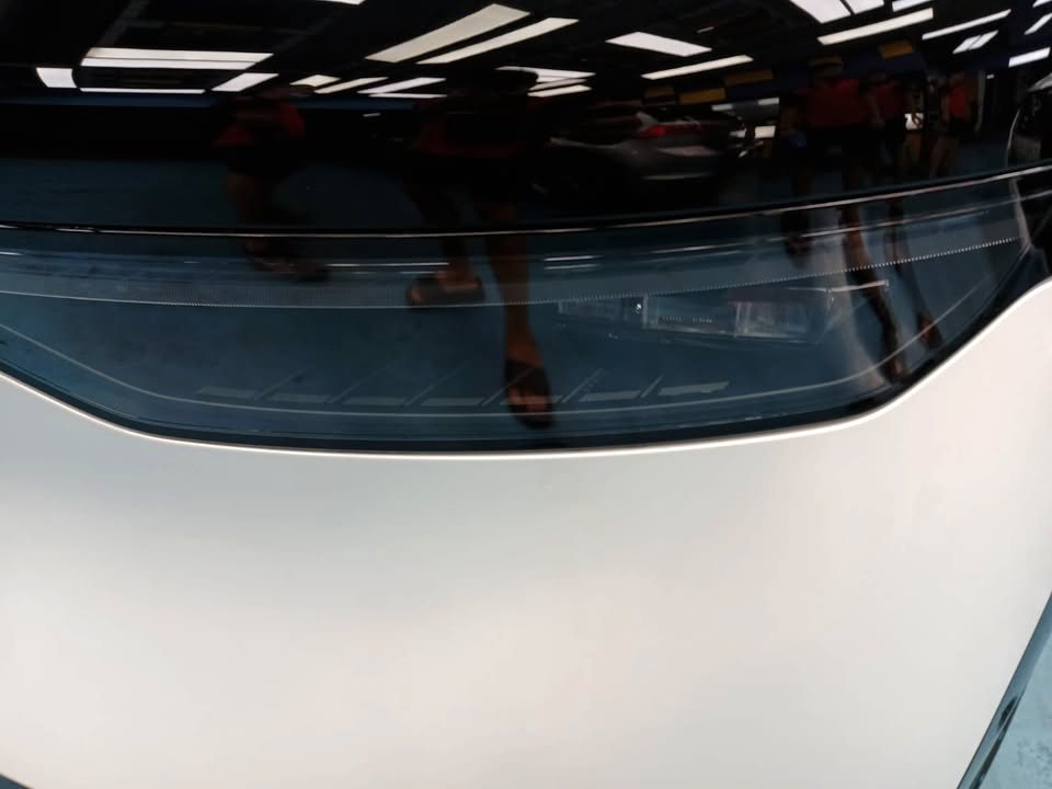 Light reflections across the white front wing below the windscreen.